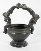 A bronze vessel, 19th century, the oval bowl with a handle formed as four cherubs,