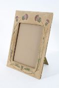 An Arts and Crafts style photograph frame, worked in silk with thistles, circa 1910,