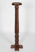 A walnut torchere, the octagonal tray top on a wrythen column with foliate details and 'X' foot,