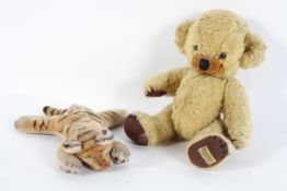 A Steiff tiger cub, asleep, no button, 25cm high; and a Merrythought golden plush teddy bear,