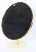 A Schreiber circular dressing table mirror, 1970's, the adjustable plate on a circular base,