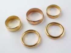 A collection of wedding rings to include four 22ct gold (hallmarked) two heavy court bands