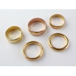 A collection of wedding rings to include four 22ct gold (hallmarked) two heavy court bands