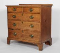 A George III oak chest of two short and three graduated long drawers, on shaped bracket feet,