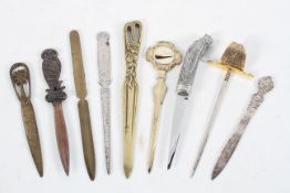 A collection of nine novelty letter openers, including one with a horse's head,