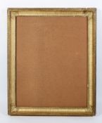 A rectangular gilt gesso picture frame, with fluted decoration and foliate corners,