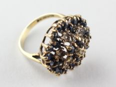 A large floral cluster ring set with sapphires and single cut diamonds.