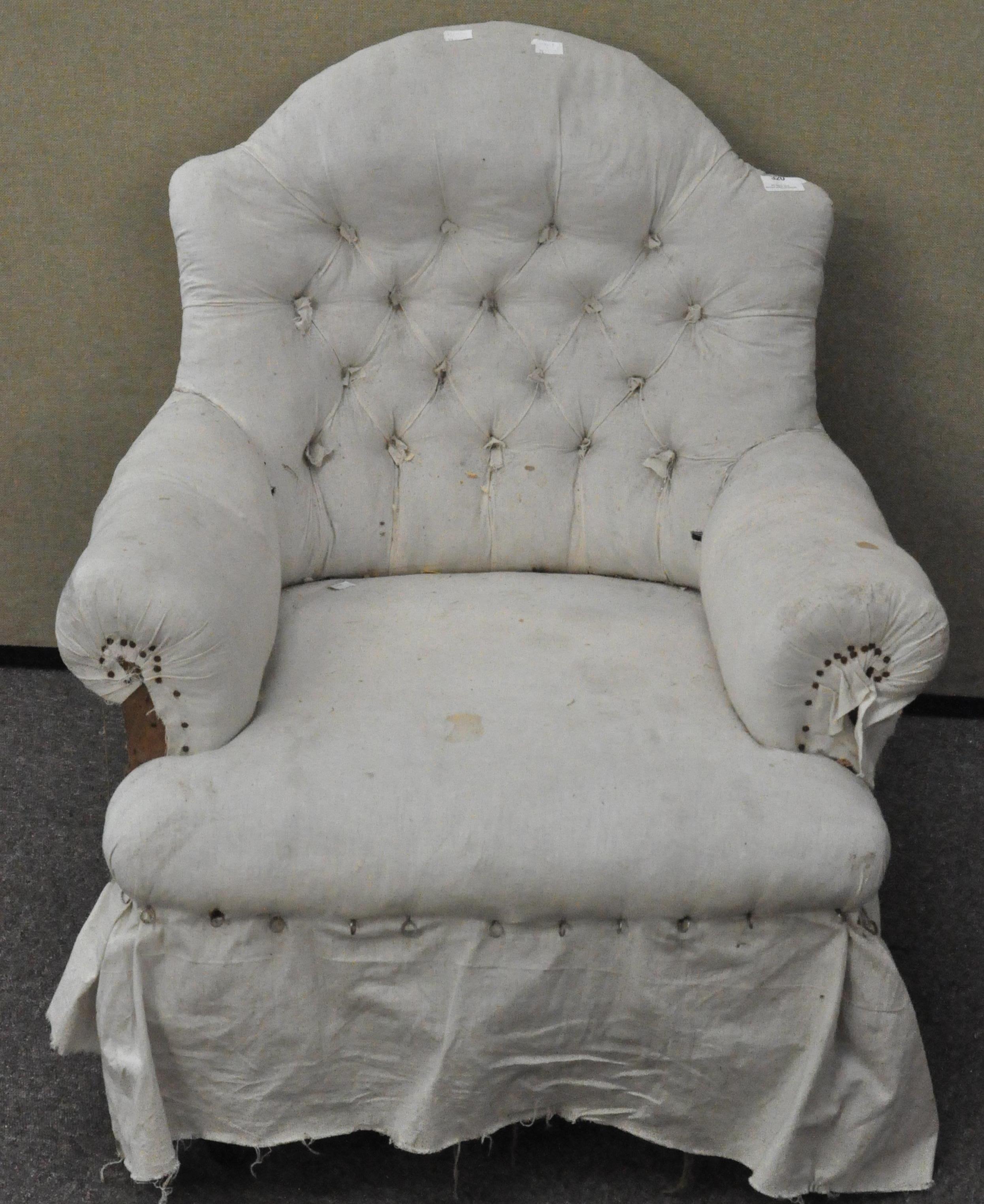 An upholstered armchair with button back,