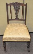 An Edwardian mahogany nursing chair with embroidered fabric seat,