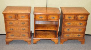 A group of three yew wood bedside cabinets : a pair with two short and three long drawers,