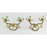 A pair of unusual ceramic wall sconces, adorned with floral decoration,