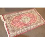 A large wool rug with cream pink and green foliate decoration,