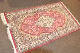 A large wool rug with cream pink and green foliate decoration,