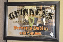 A vintage Guinness advertising mirror in stained wood frame,