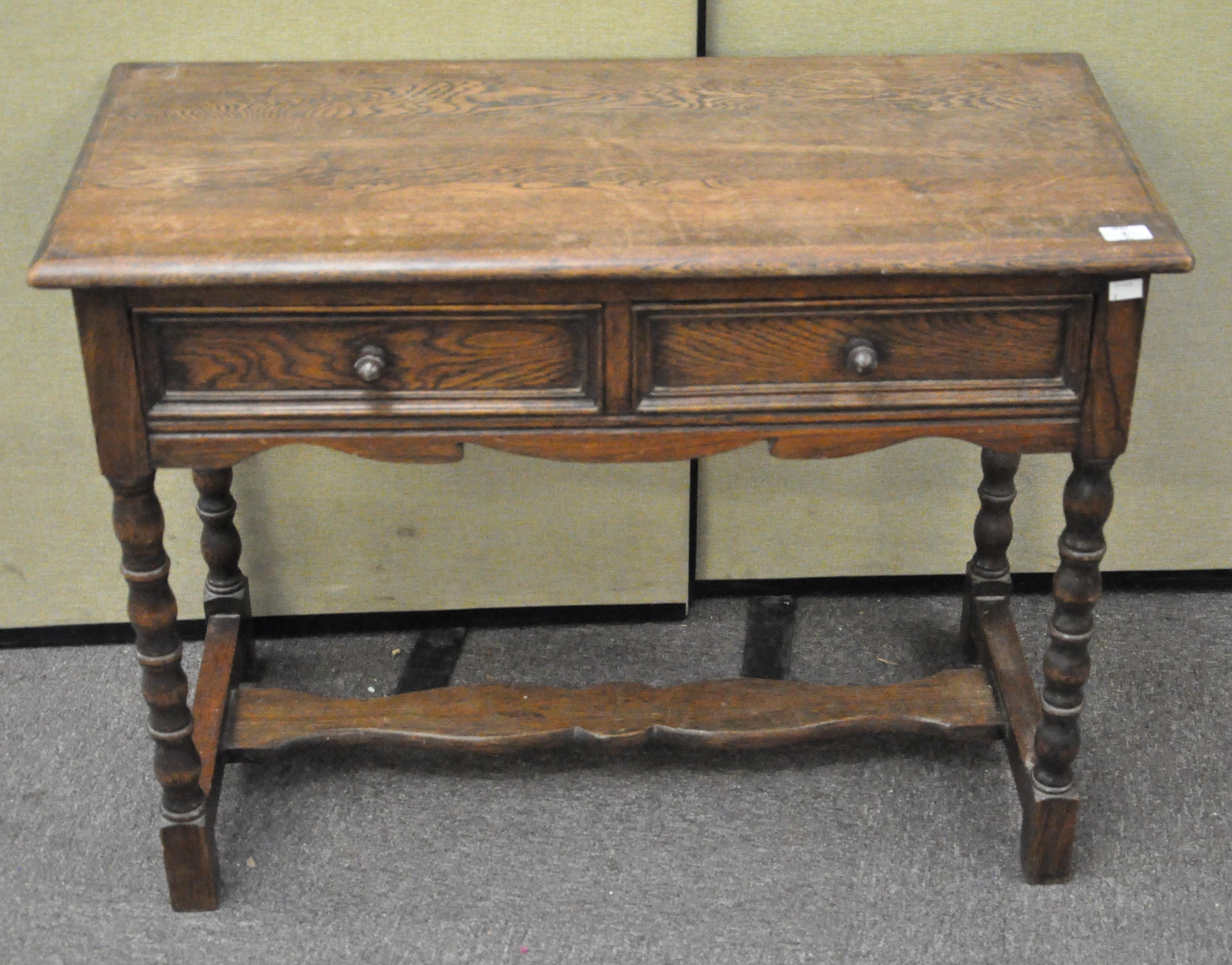 A barley twist oak side table/desk with two drawers to the front,