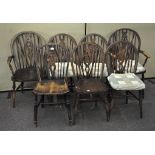 A set of seven wheel back dining chairs with removable cushions,