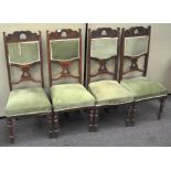 A set of four oak dining chairs, with upholstered seats and backs, raised on turned supports,