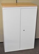 A modern metal storage cabinet with light wood top,