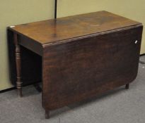 A 19th century mahogany drop leaf dining table raised on turned legs,