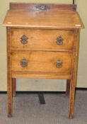 An early 20th century two drawer oak hall unit with carved motifs to the legs and back,