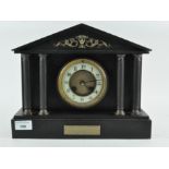A late Victorian slate mantle clock, the enamel dial with Arabic numerals denoting hours,