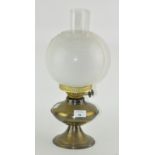 A vintage brass oil lamp with glass shade and funnel,