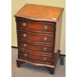 A small chest of four drawers, each drawer with two metal pull handles,