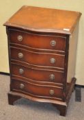 A small chest of four drawers, each drawer with two metal pull handles,