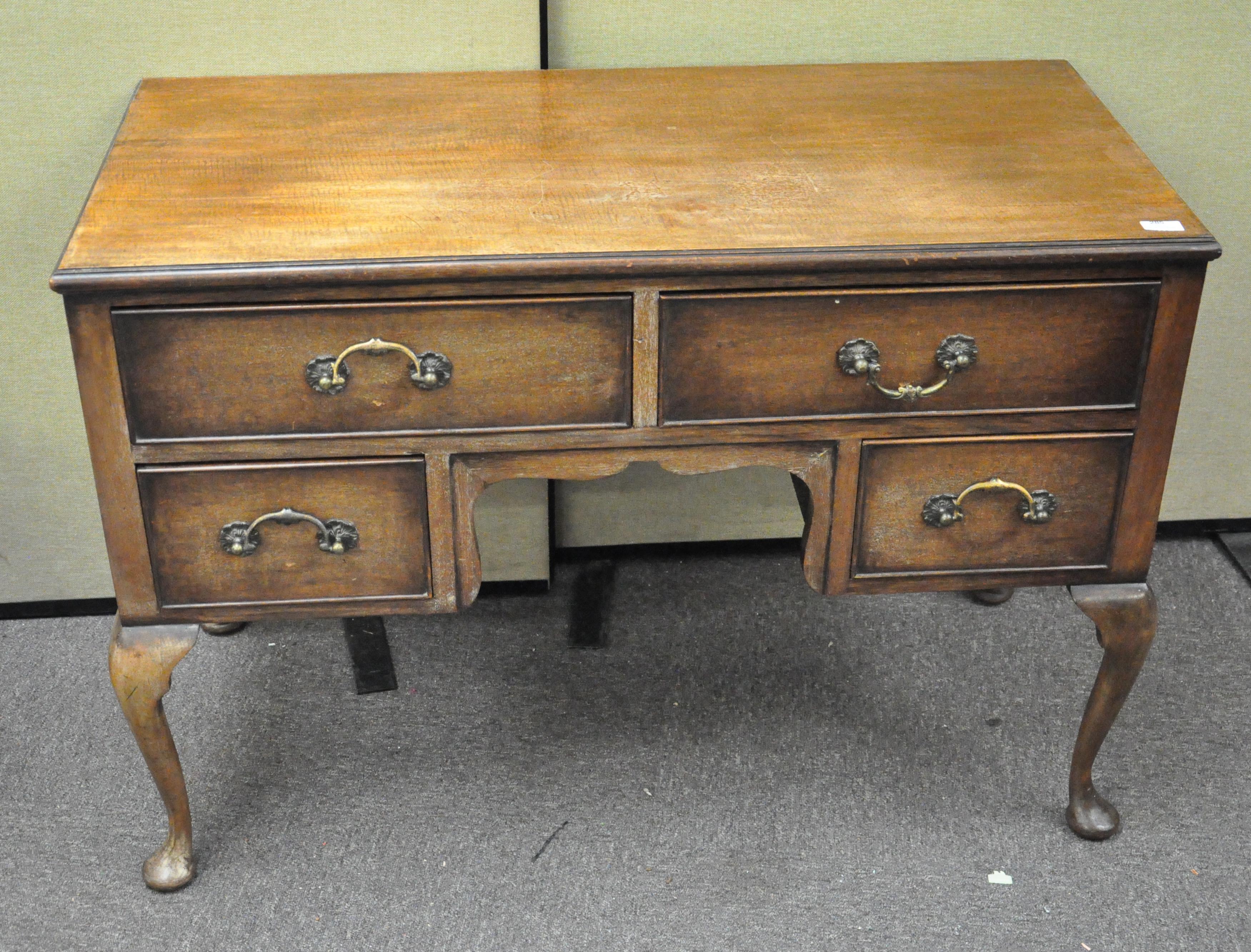 A mahogany kneehole desk with two long and two short drawers, raised on cabriole legs,