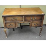A mahogany kneehole desk with two long and two short drawers, raised on cabriole legs,