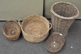 A group of four wicker, baskets of various sizes and designs,