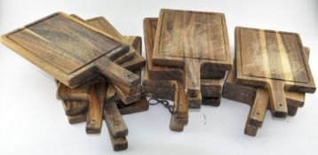 A collection of fourteen wooden chopping boards,