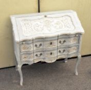A painted oak French style serpentine fronted writing desk / bureau having fall front door
