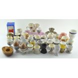 A collection of assorted ceramic egg cups including Royal Doulton 'Bunnykins' and Doulton,