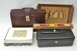 A brown leather briefcase, metal tin,