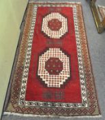 A wool rug, 20th century, with red ground woven with black and cream geometric ornament,