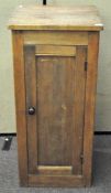 A large pine pantry cupboard, the single door revealing three shelves,