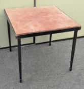 A vintage ebonised card table having folding legs and upholstered top,