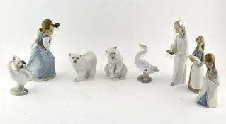 A collection of eight Lladro figures, including two polar bears, two geese and a girl with puppy,