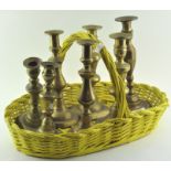 A group of brass candlesticks, comprising: three pairs and one single (one basket),