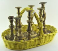 A group of brass candlesticks, comprising: three pairs and one single (one basket),