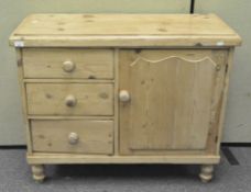 A vintage pine kitchen cupboard with three drawers to one side and a single door cupboard