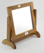 An Arts and Crafts style oak small dressing table mirror, supported on arched feet,