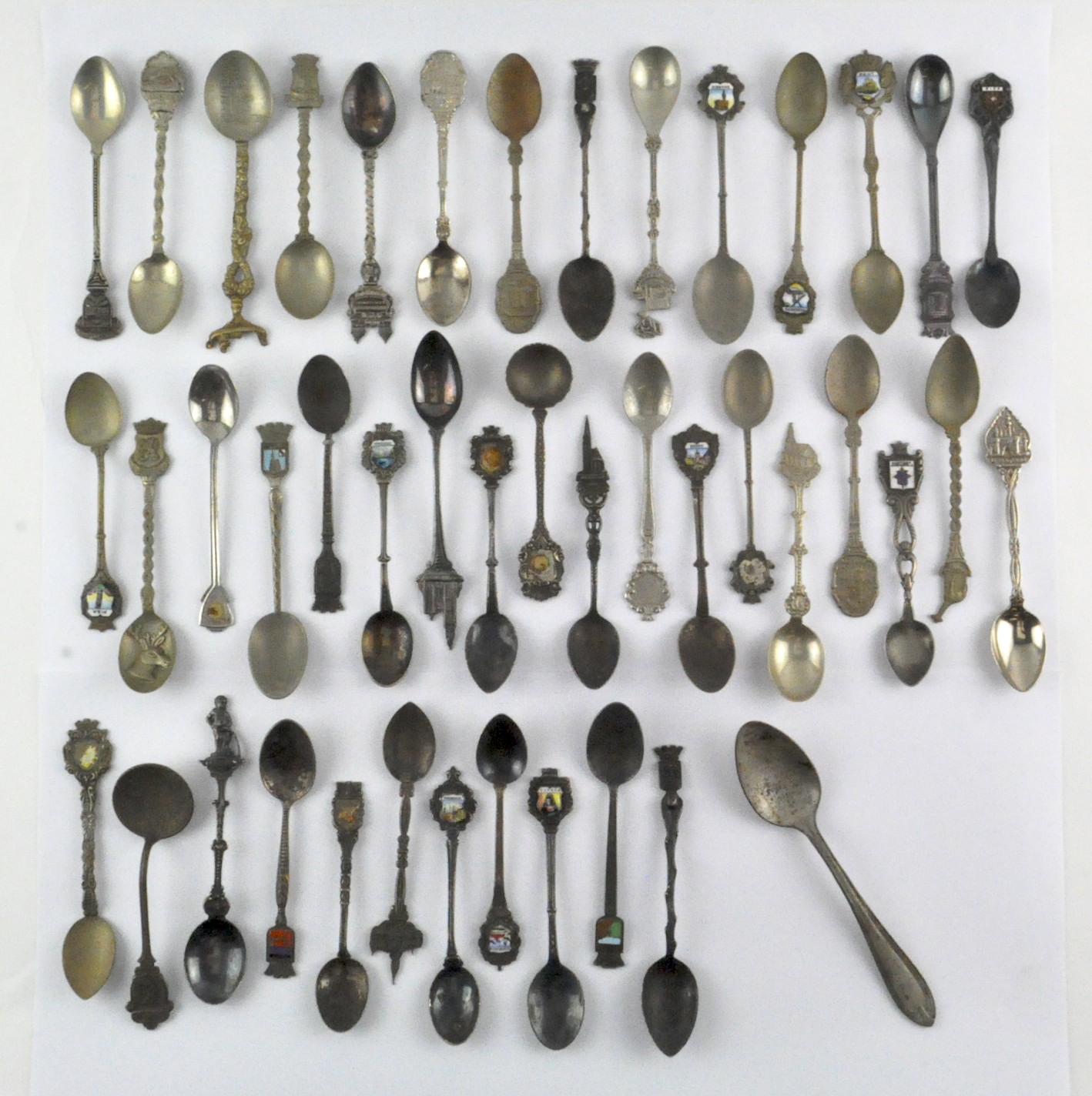 A collection of silver plated commerative spoons from around the world,