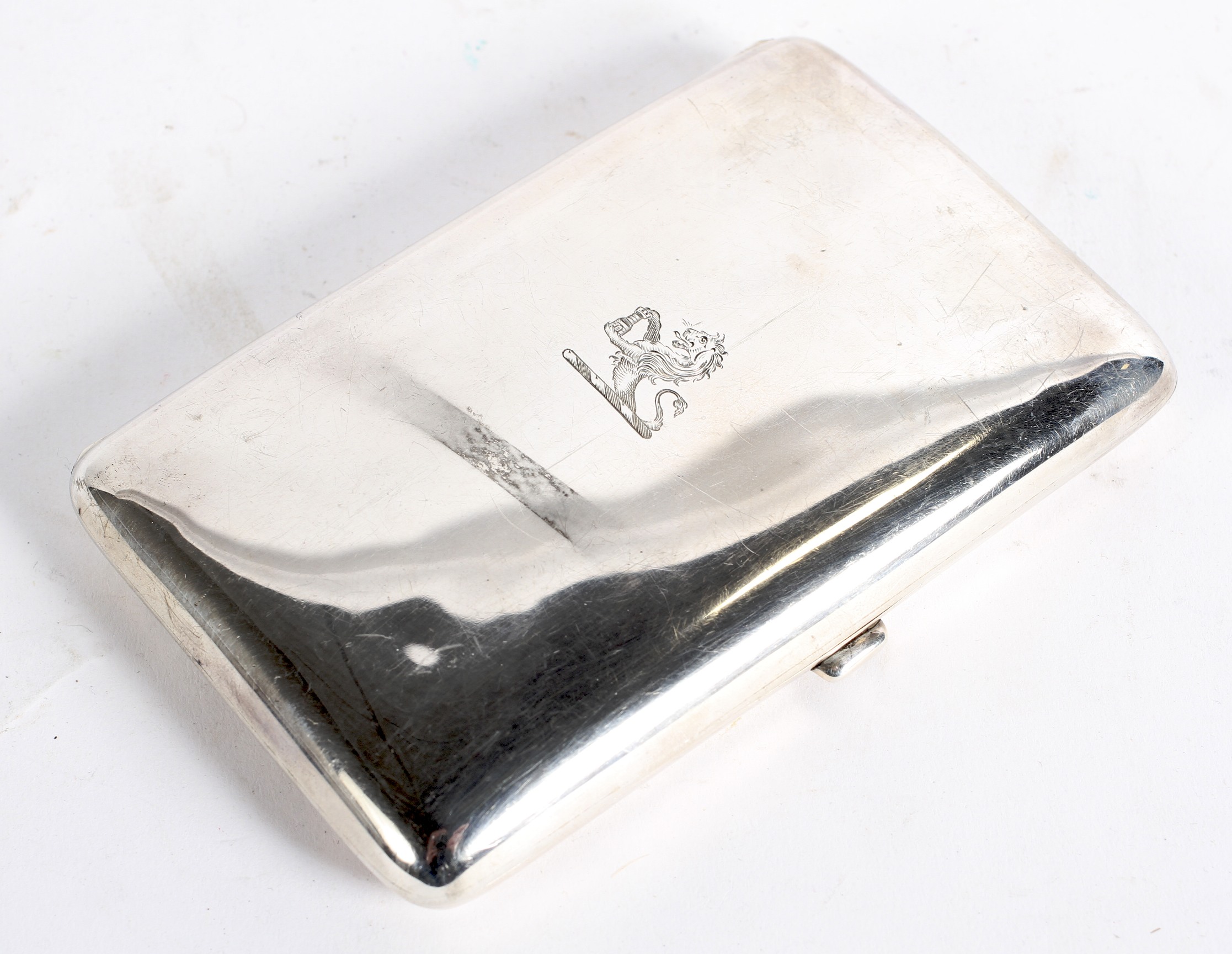 A George V silver cigar case of rectangular curved form with engraved coat of arms to the lid,