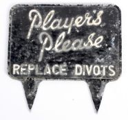 An aluminium golf sign saying 'Players Please Replace Divots,