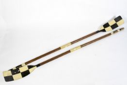 A pair of wooden rowing oars with painted chequered black and white paddles, mid-20th century,
