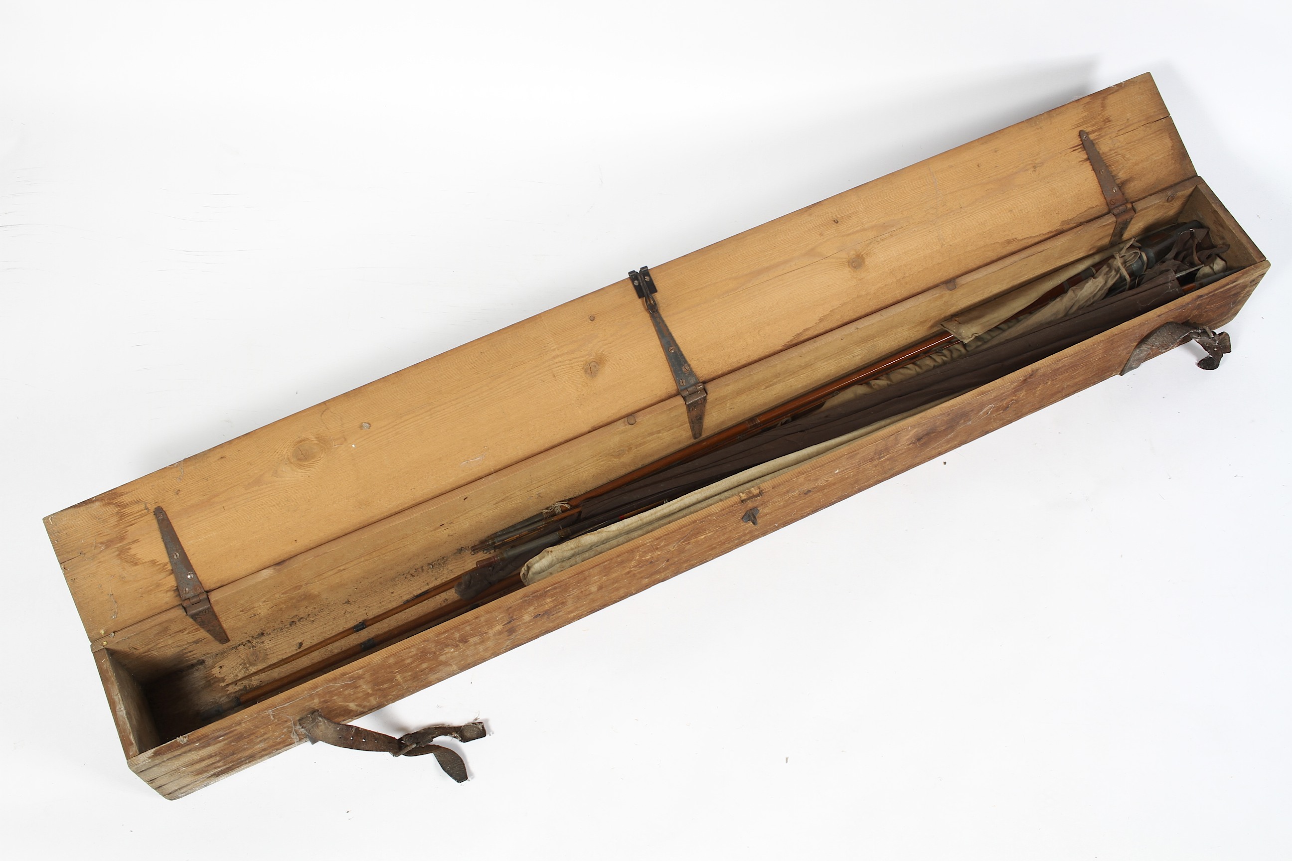 A large wooden travelling rod case containing a quantity of early cane,
