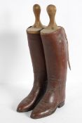 A pair of lady's tan leather riding boots, with buckled strap,