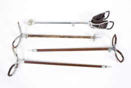 Four vintage shooting sticks, each folding leather mounted example on wood or metal stem,